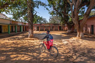 Photo of a child on a bike in the courtyard of a school in India