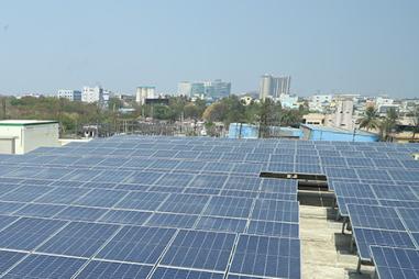 Rooftop solar panels in the foreground with a cityscape in the background