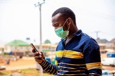 Photo of man with facemask and mobile phone